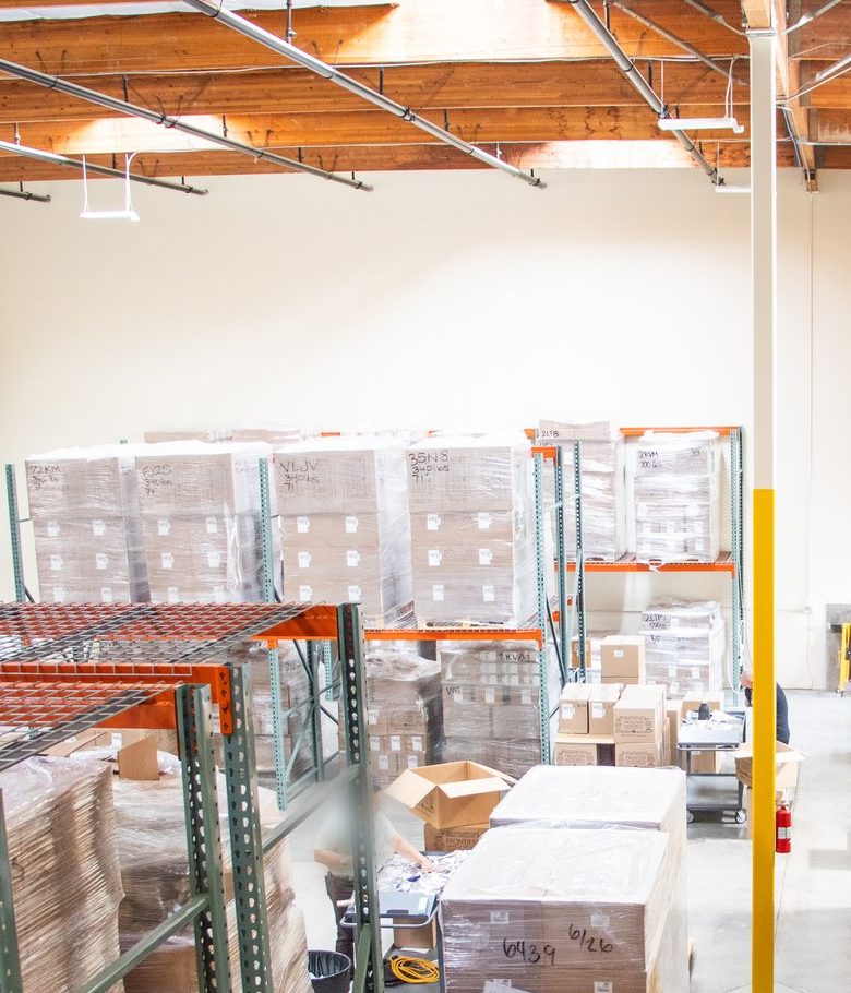 The StockCadence prep floor in Paramount, Los Angeles: racked, shrink-wrapped pallets staged for FBA shipments.